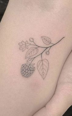 a small black and white tattoo on the back of a woman's left leg