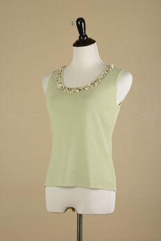 Vintage 1990s Y2K Pastel Green Tank Top. Crafted from a thick and stretchy rayon blend fabric, this tank top is adorned with a uniquely beaded neckline. It features clusters of green beads and seashells, varying in shades, sizes, and shapes. This structured tank top is in excellent condition Shoulder to Shoulder: 13" Strap Length: 2.5" Bust: 34" Waist: 32" Hips: 36" Length: 21" Elegant Green Stretch Tank Top, Spring Stretch Embellished Tank Top, Pastel Tank Top, Spring Embellished Stretch Tank Top, Spring Beaded Fitted Tank Top, Sage Green Tank Top, Fitted Vintage Beaded Tops, Green Cotton Y2k Tank Top, Vintage Beaded Sleeveless Top