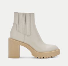 a woman's white boot with wooden heel and chunky soles on the side