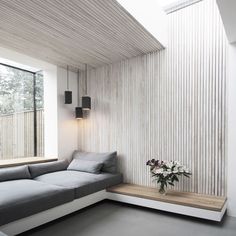 a living room filled with furniture and a window next to a wooden flooring wall