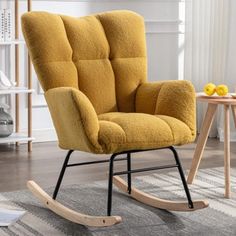 a yellow rocking chair sitting on top of a rug