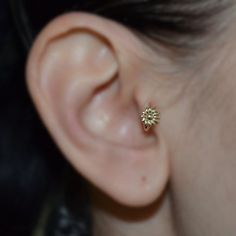 a close up of a person's ear with a small flower in the middle