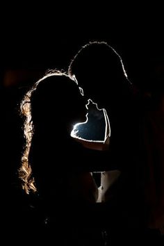 two people are kissing in the dark