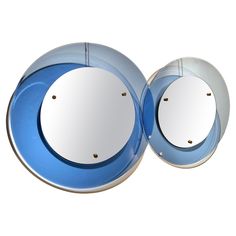 two round mirrors sitting next to each other on top of a white surface with blue trim