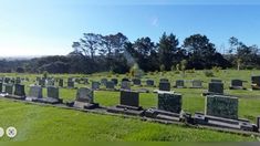 a cemetery with many headstones and trees in the background