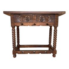 an old wooden table with two drawers on one side and carvings on the other end