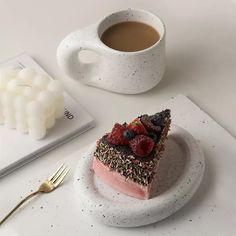 a piece of cake sitting on top of a plate next to a cup of coffee