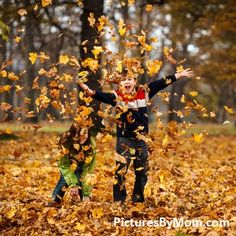 two children are playing in the leaves