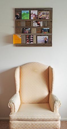 a chair sitting in front of a wall with pictures on it