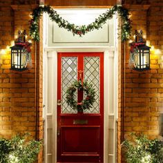 a red door with wreaths and lights on it