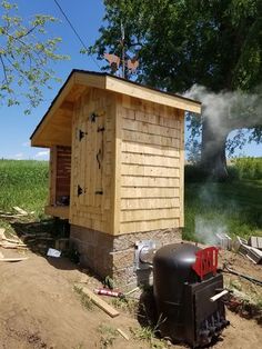 a small wooden outhouse sitting on top of a dirt field