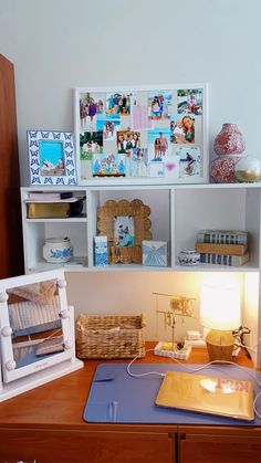 a wooden desk topped with lots of pictures and other items next to a shelf filled with books