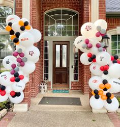 balloons are arranged in the shape of letters and numbers on an entrance way to a brick building