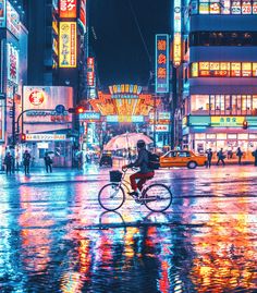 a person riding a bike in the middle of a city at night with neon lights