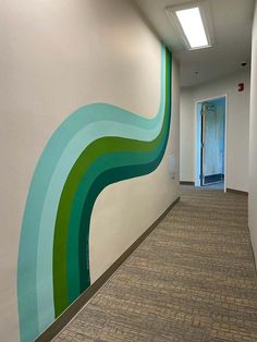 an office hallway painted with green and blue waves