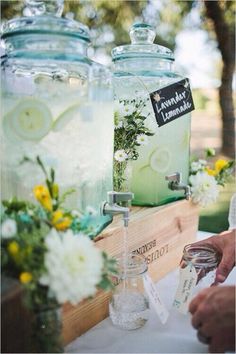 two jars filled with lemonade and flowers on top of a table