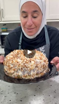 a woman holding a cake on top of a pan