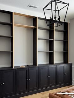 a living room filled with lots of black bookshelves