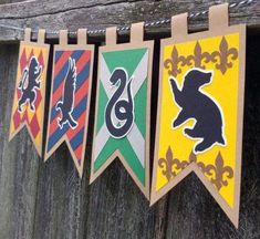 several pennants hanging from a wooden fence