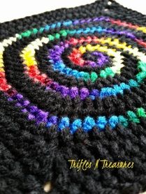 a close up of a crocheted rug with multicolored circles on it