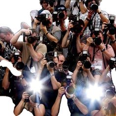 a large group of people with cameras taking pictures