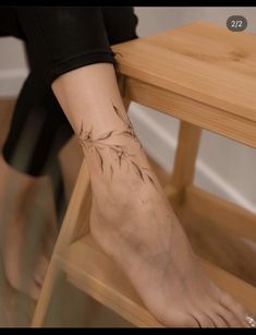 a woman's foot with a flower tattoo on her left ankle and the bottom part of her leg