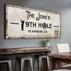 a sign that says the jones's 9th hole stands in front of some bar stools