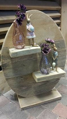 two vases with flowers in them sitting on a wooden shelf next to a brick floor