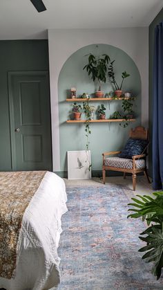 a bed room with a neatly made bed next to a green door and plant shelves