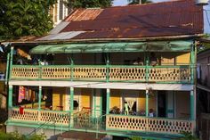 an old house with green and yellow balconies