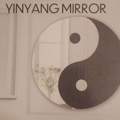 an advertisement for yin yang mirror with a black and white ying - yang symbol on it