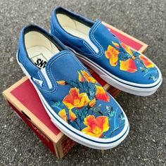 California poppy state flowers on these navy Vans slip on shoes. We buy each pair of blank shoes BRAND NEW from the Vans retail store. The ink is permanent and will never come off. Made in the USA. This price includes everything: shoes, artwork, and shipping. Please message us with any questions!Sizes listed are in US sizing scale. If you have any issues with your order, please feel free to reach out to us and we will be more than glad to help you! Note: Blvd Custom is in no way affiliated with Hand Painted Vans Slip On, Painted Sneakers Diy, Painted Vans Slip On, Painting Vans, Diy Vans, Sneaker Painting, Custom Painted Vans, Shoes Artwork, Black Slip On Vans