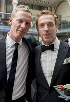 two men in tuxedos are posing for the camera