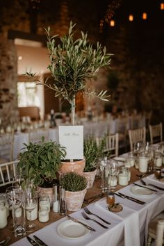 the table is set with flowers and place settings for guests to sit down at it