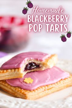 homemade blackberry pop tarts on a white plate with pink icing and strawberries