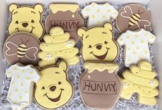 a box filled with lots of decorated cookies in the shape of winnie the pooh