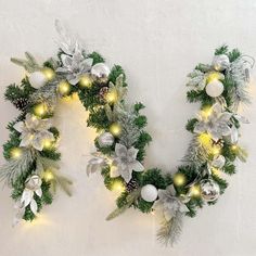 two christmas wreaths with lights and decorations on the wall next to eachother