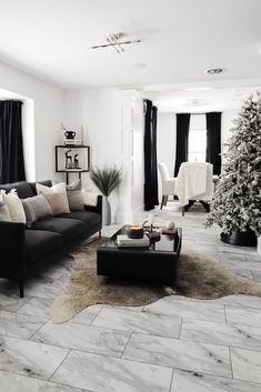 a living room filled with furniture and a christmas tree in the middle of the room