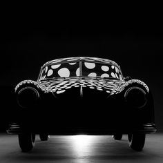 a black and white photo of a car with polka dots on it's hood