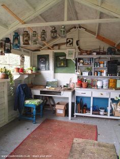 a room filled with lots of clutter and hanging pots on the wall next to a desk