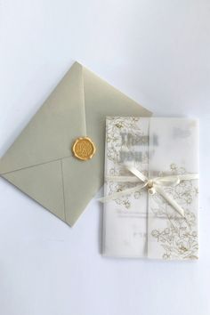 an envelope with a wax stamp on it next to a wedding card and tie box