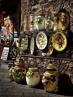 there are many vases and plates on the wall