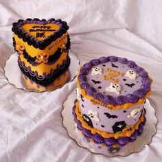 two decorated cakes sitting on top of a white table