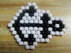 a wooden table topped with white and black beads