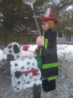 a fireman and dog mailbox in the snow with a broom sticking out of it's mouth