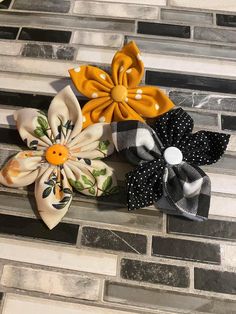 three different types of hair bows sitting on top of a tiled floor next to each other