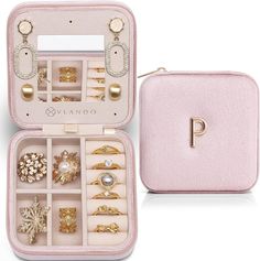 an open pink jewelry case filled with lots of different types of rings and brooches