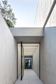 the hallway is lined with concrete walls and black metal railings that lead to an entrance