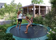 three children playing on a trampoline in the garden