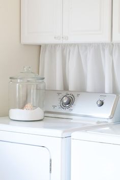 a white washer and dryer sitting next to each other in front of cabinets